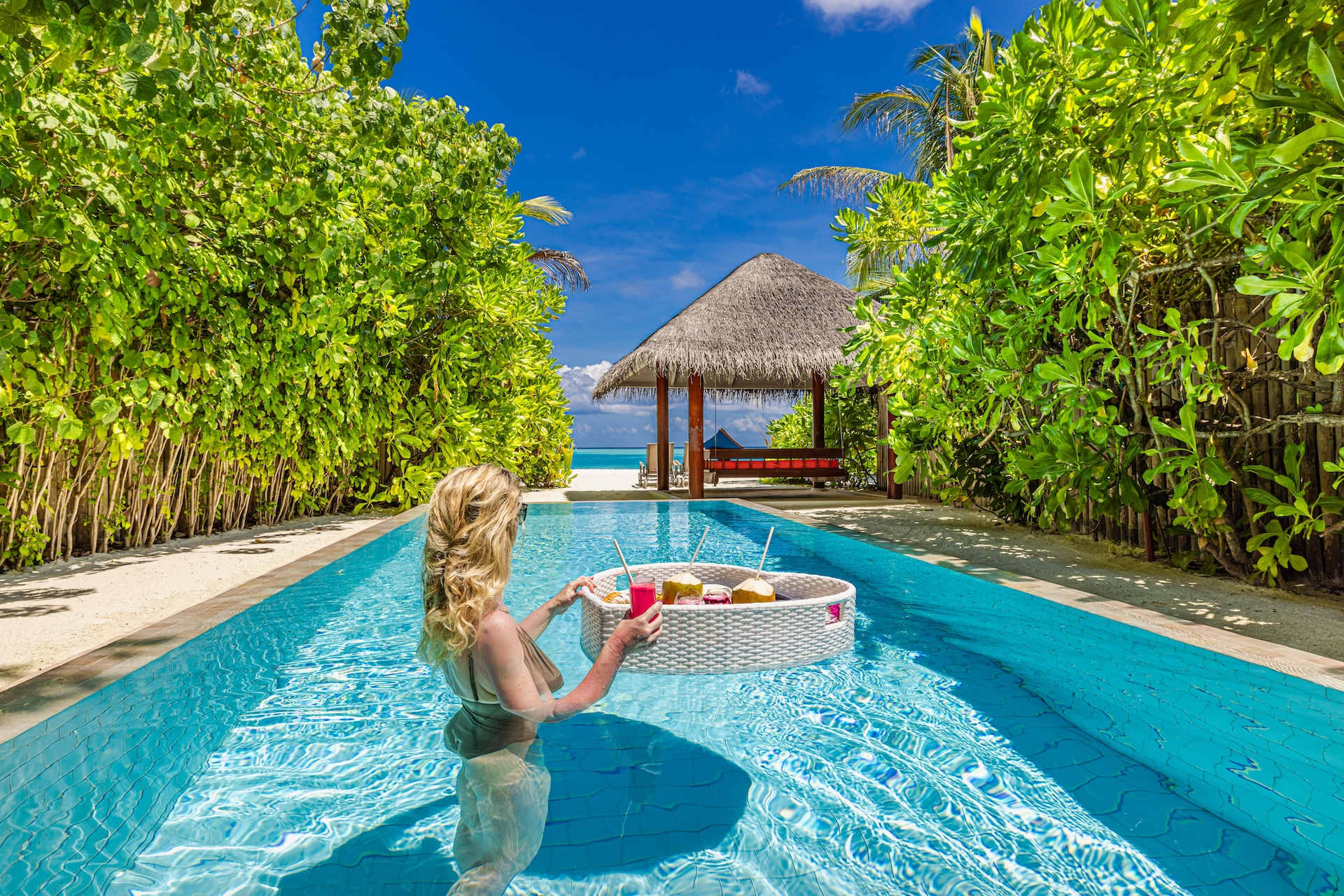 Hotel marketing of beautiful luxury Maldives resort with woman having breakfast in pool